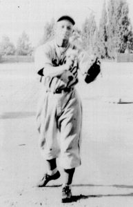 A baseball player is holding his glove in the air.