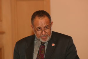 A man in suit and tie sitting down.