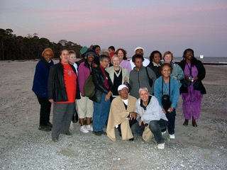 A group of people standing on top of a beach.