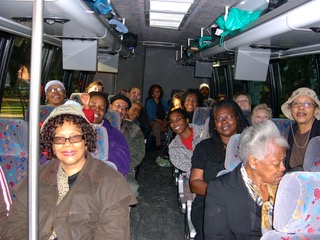 A group of people sitting on the back of a bus.